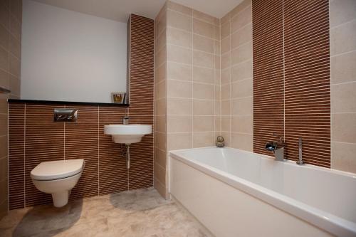 格拉斯哥The Spires Serviced Apartments Glasgow的浴室配有卫生间、浴缸和水槽。