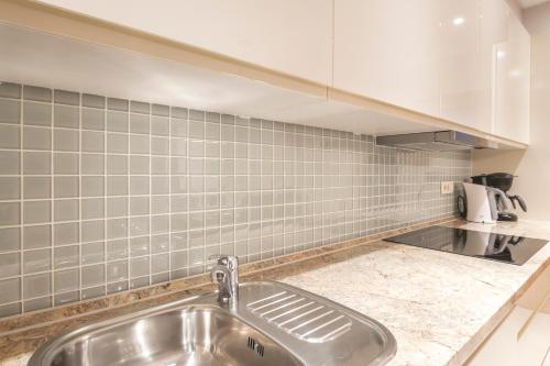 马林斯卡Luxury Apartments Villa Matea 1的一间带水槽和瓷砖墙的厨房