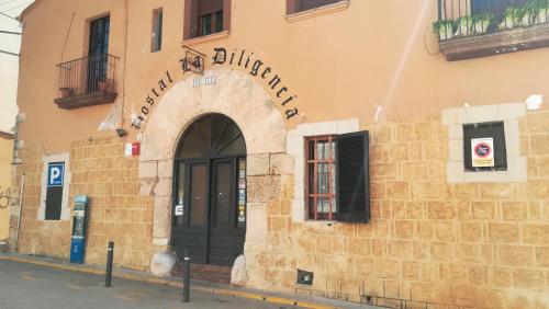 库尼特Hostal Restaurante La Diligencia的建筑的一侧有一道黑色的门