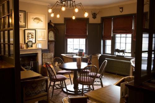RuabonWynnstay Arms, Ruabon, Wrexham的用餐室设有桌椅和窗户。