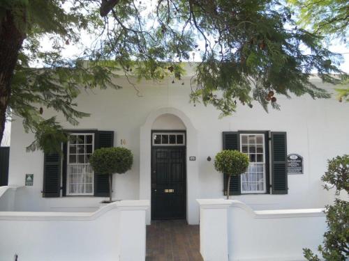 格拉夫-里内特De Kothuize 10的白色的房子,有黑色百叶窗和门