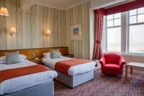 布莱克浦选择（英国）克里夫斯酒店的酒店客房,设有两张床和一张红色椅子