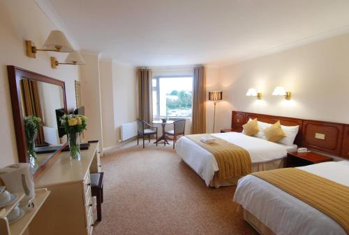 多尼戈尔多尼歌中心酒店的酒店客房设有两张床和一张桌子。