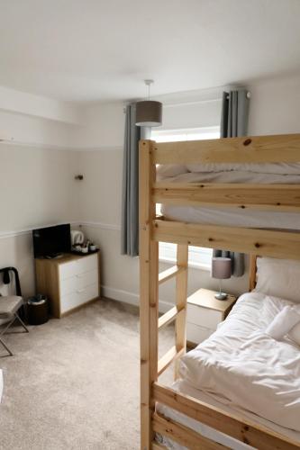 锡豪西斯Longstone House Bed & Breakfast的一间卧室配有双层床和书桌