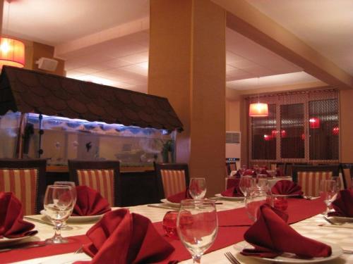 德巴尔维奈克酒店的餐厅设有一张带红餐巾和酒杯的桌子