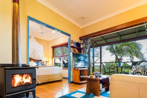 马莱尼Lillypilly's Cottages & Day Spa的一间带壁炉和床的客厅以及一间卧室。