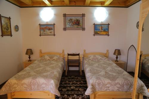 撒马尔罕Rabat Boutique Hotel的一间卧室配有两张床和两盏灯。