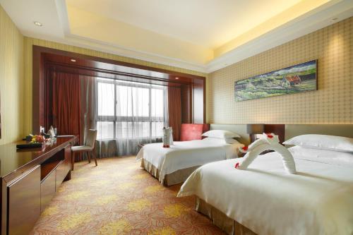 广州京溪礼顿酒店的酒店客房配有两张床和一张书桌