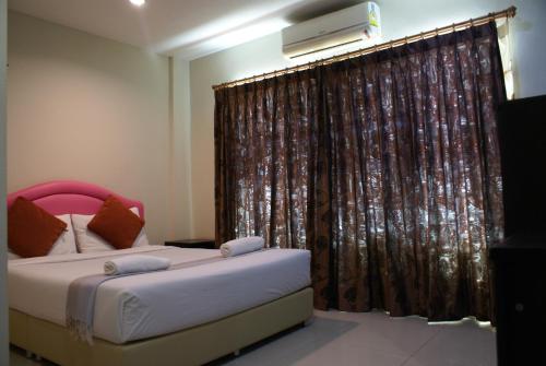 清迈潘德平酒店的一间卧室设有两张床和窗户。
