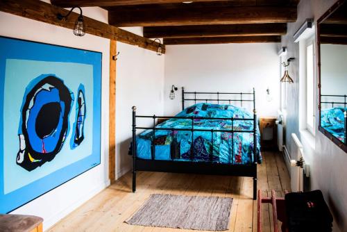 艾勒斯克宾安代伦旅馆的一间卧室配有一张带蓝色棉被的床