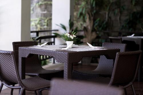 长滩岛长滩岛雷西登西亚酒店的桌子上摆放着椅子,花瓶上放着花