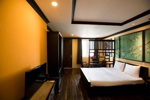 胡志明市Ipeace Hotel - Bùi Viện Walking Street的卧室配有一张床,墙上挂着一幅大画