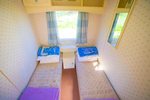 弗瓦迪斯瓦沃沃Domki Holenderskie Red Ice的小房间设有两张床和窗户