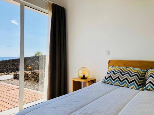 Terra do PãoCasa da Rocha的一间卧室配有一张床,享有海景