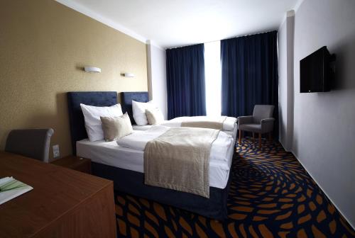 比尔森中央酒店的一间设有大床和窗户的酒店客房