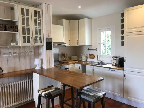 安德诺莱斯贝恩Tamina的厨房配有白色橱柜和木桌