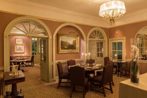 博尔顿阿比The Devonshire Arms Hotel & Spa - Skipton的一间带桌椅和吊灯的用餐室