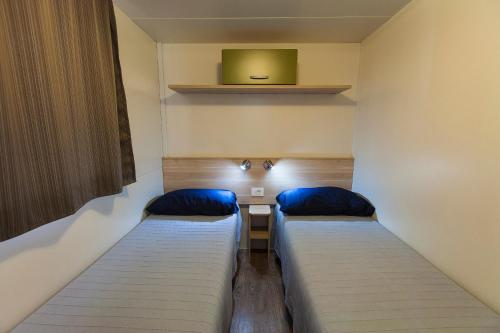 索托马里纳Camping Tredue的客房设有两张床和一台墙上的电视。