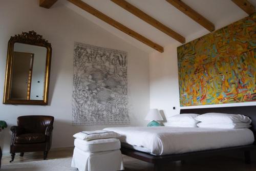 IrgoliGulf of Orosei Luxury Mediterranean House的一间卧室配有一张床、镜子和椅子