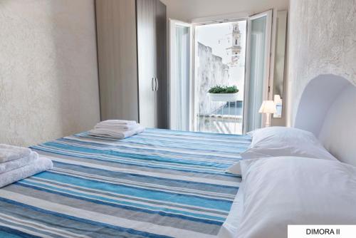 莫诺波利La Dimora sull'Arco的一间卧室配有一张带蓝白色毯子的床