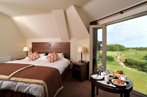 索普尼斯Thorpeness Golf Club and Hotel的一间卧室设有一张床和一个大窗户