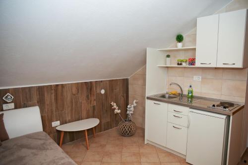 科托尔阿尼塔旅馆的小厨房配有白色橱柜和桌子