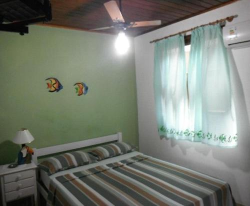 坎布里Alebelhinha Residencial Camburi Pousada的一间卧室设有一张床和一个窗口