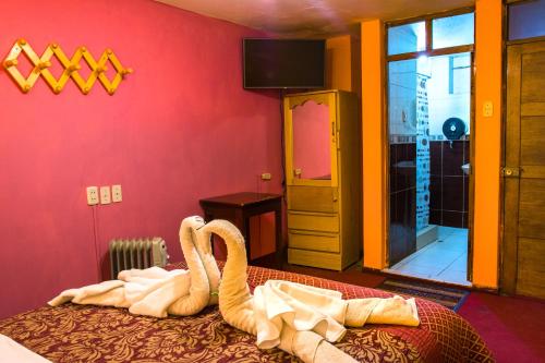 普诺圣女拉斯涅韦斯II旅馆的一间房间,床上放着两个天鹅