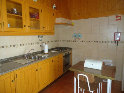 里戈尔Casa Campo e Praia的厨房配有木制橱柜、水槽和柜台。