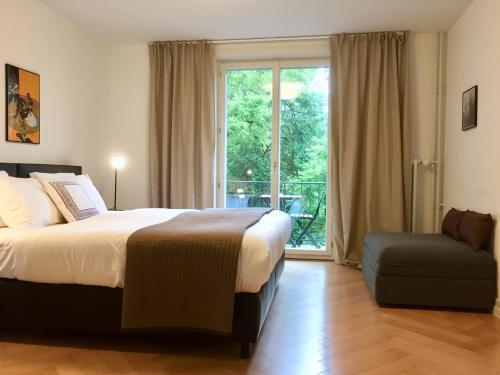 苏黎世VIADUKT公寓式酒店的卧室配有床、椅子和窗户。