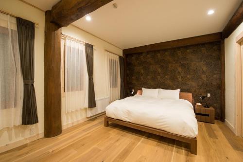 二世古Koho的卧室设有一张白色大床和木地板