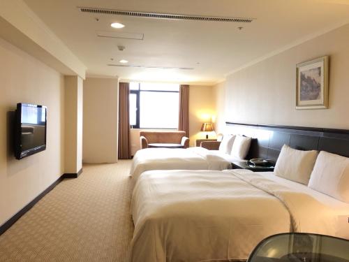 桃园市中悦国际大饭店的酒店客房设有两张床和电视。