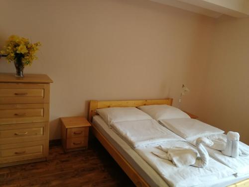 科尔别卢夫Willa Helvetia Wellness & SPA的一间卧室配有一张带白色床单的床和梳妆台。