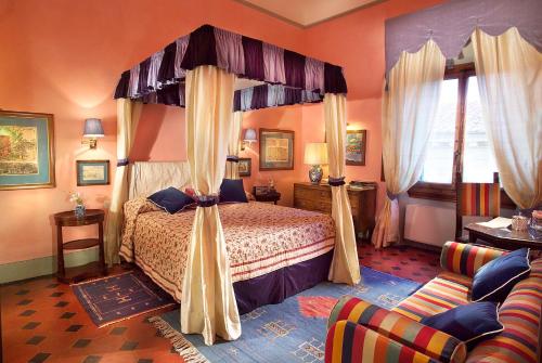 佛罗伦萨Antica Dimora Johlea的一间卧室配有天蓬床和沙发