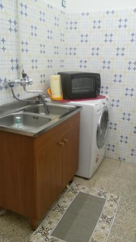 阿拉代奥casa Anna的厨房配有水槽和洗衣机