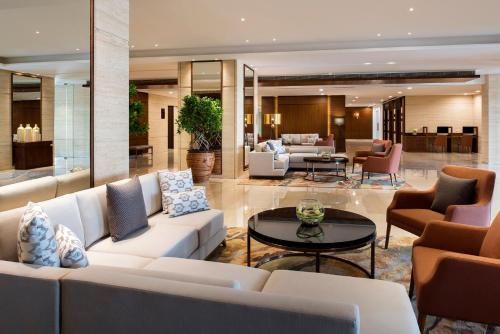 马斯喀特Fraser Suites Muscat的客厅配有白色的沙发和桌子