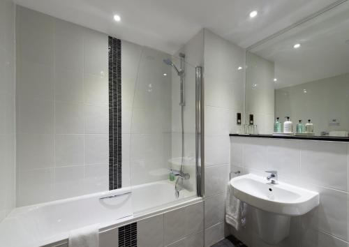 拉纳克新拉纳克磨坊酒店的白色的浴室设有水槽和淋浴。
