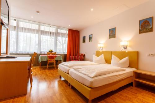 MichelauHotel Spitzenpfeil的酒店客房配有一张床铺和一张桌子。