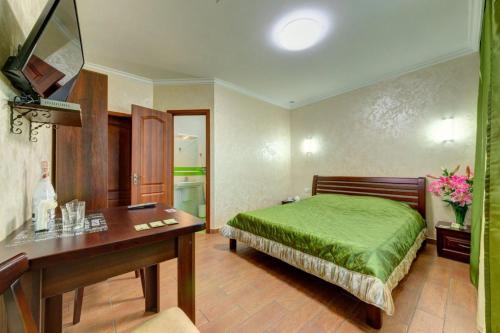 基辅Лика Отель的一间卧室配有一张绿色的床和一张书桌
