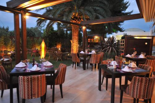 沃洛斯卡洛尼酒店的餐厅在庭院里设有桌椅