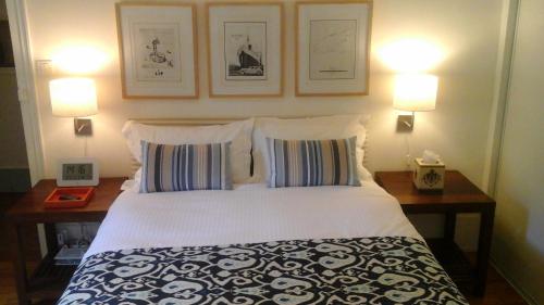 博讷博纳城市套房公寓的一间卧室配有一张带两盏灯和两个枕头的床。