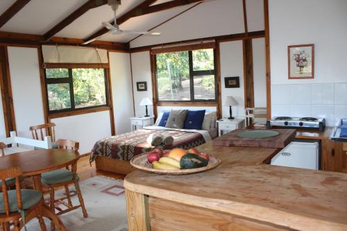 克拉格斯Treehouse Cottage的一间卧室配有一张床和一张桌子及一碗水果