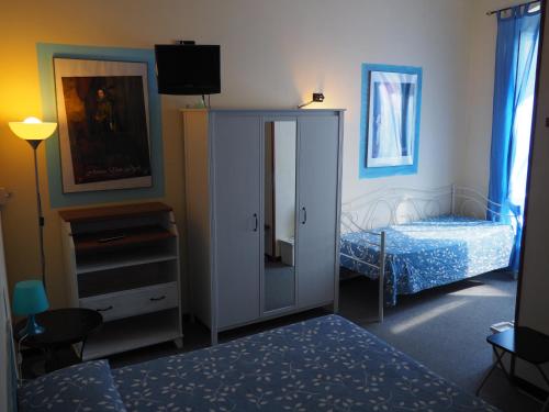 阿伦扎诺hotel albatros的一间卧室配有一张床和一个带镜子的橱柜