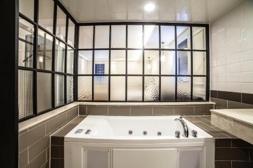 光州Hotel Stay 53的带浴缸的浴室和窗户