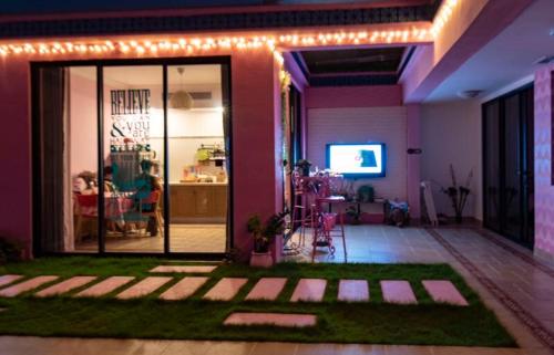 惠东万科双月湾独栋别墅的客厅设有粉红色的墙壁,卧室设有草地