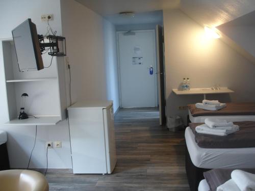 多特蒙德多特蒙德城市膳食公寓的一间小客房,配有两张床和一间浴室