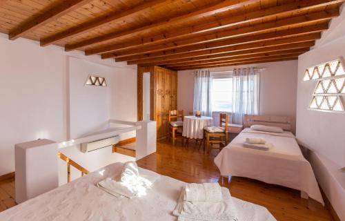 胡拉吉亚Antoninis Village的一间带两张床的房间和一间带桌子的用餐室