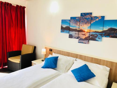 多马索风帆公寓式酒店的一间卧室配有一张带蓝色枕头的床