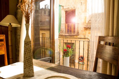 锡古恩萨Alojamientos Victoria的一张桌子,带窗户,享有阳台的景色