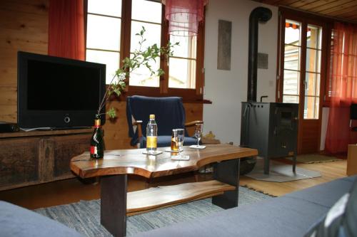 阿德尔博登伯格多尔公寓的客厅配有木桌和电视。